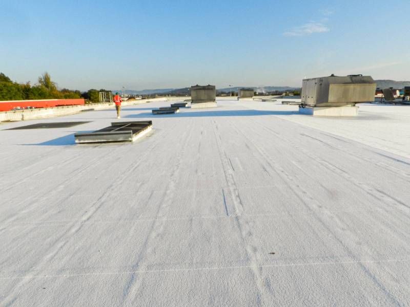 Peinture blanche isolante à Aubagne : solution Cool Roof pour toiture plate de concession automobile moderne